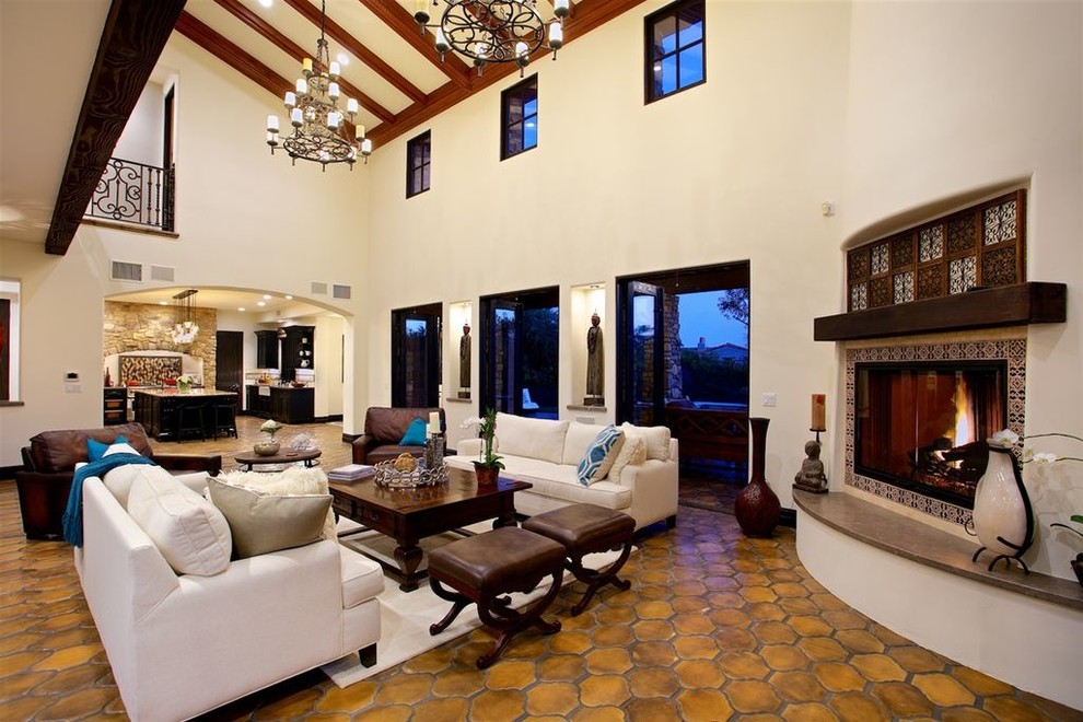 Geräumiges, Offenes Mediterranes Wohnzimmer mit Hausbar, Terrakottaboden, Eckkamin, gefliester Kaminumrandung und orangem Boden in San Diego