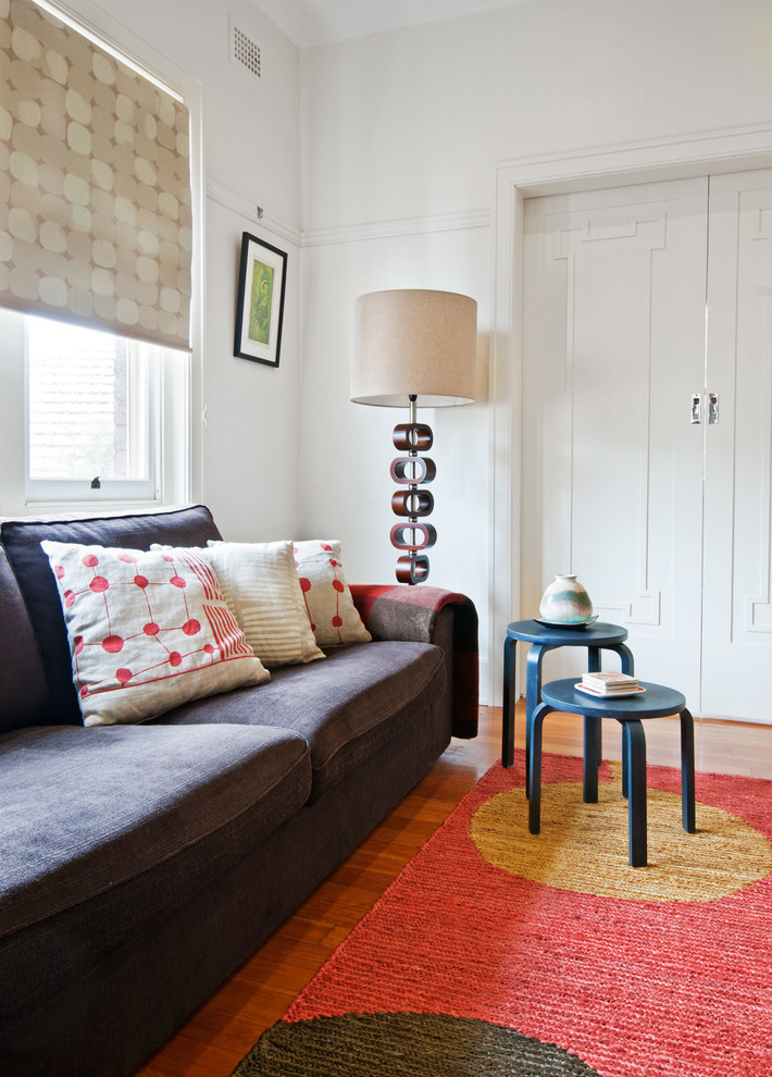 Idée de décoration pour un petit salon bohème ouvert avec un mur beige et un sol en bois brun.
