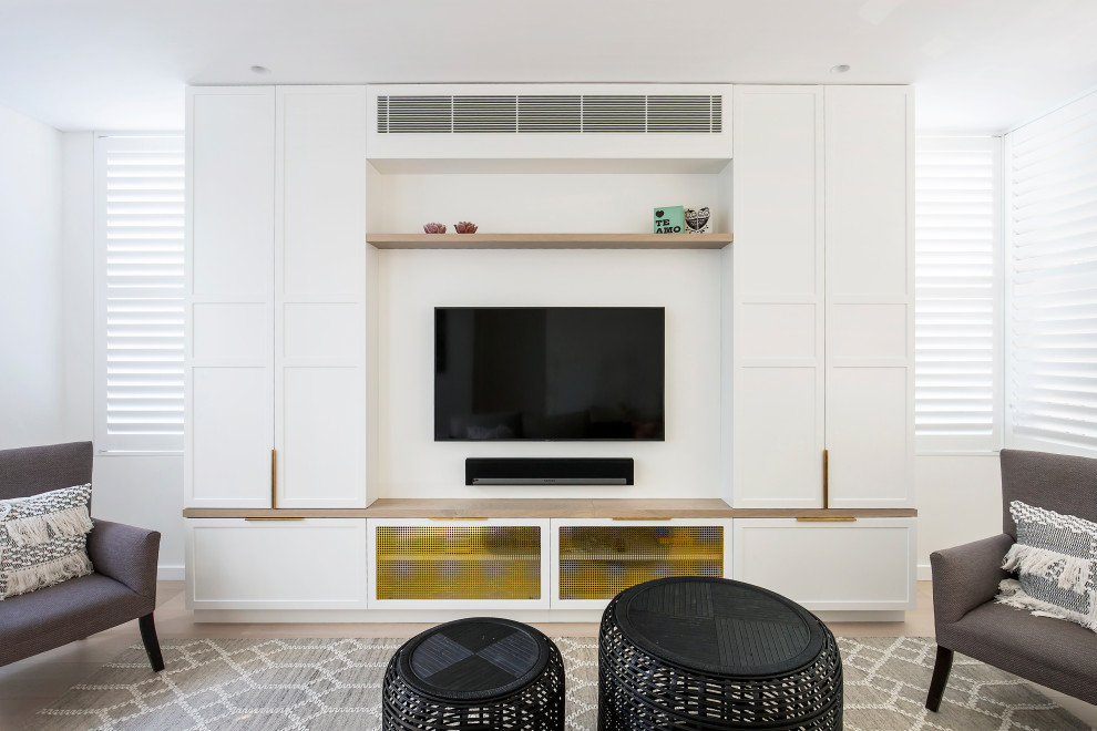 Ejemplo de salón actual con paredes blancas, suelo de madera clara, pared multimedia y suelo beige