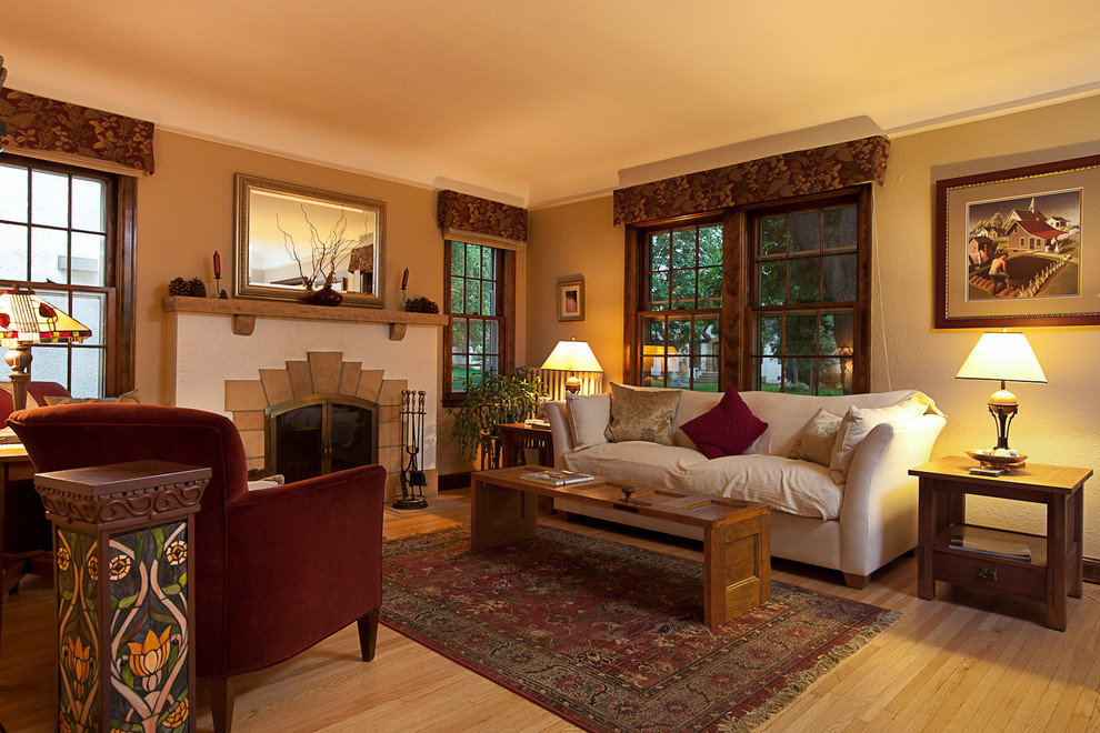 Стильный дизайн: гостиная комната в классическом стиле с светлым паркетным полом и стандартным камином - последний тренд