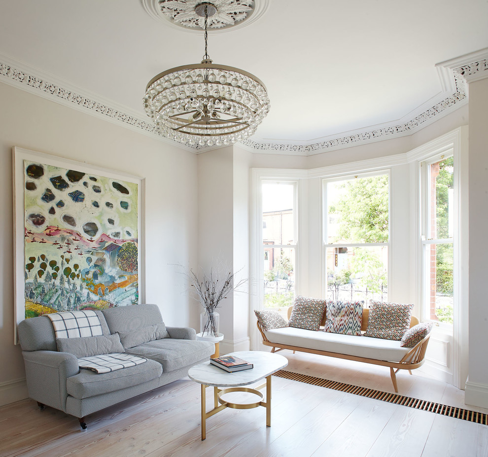 Classic living room in Dublin with white walls, light hardwood flooring, a standard fireplace and a stone fireplace surround.