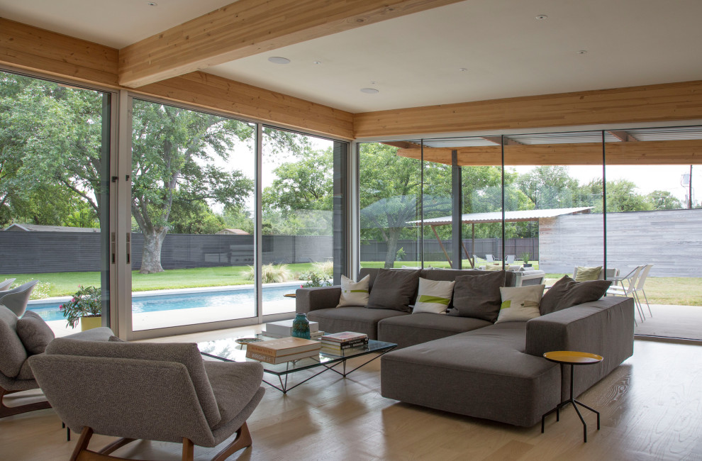 Ejemplo de salón abierto minimalista sin televisor con suelo de madera clara y suelo beige