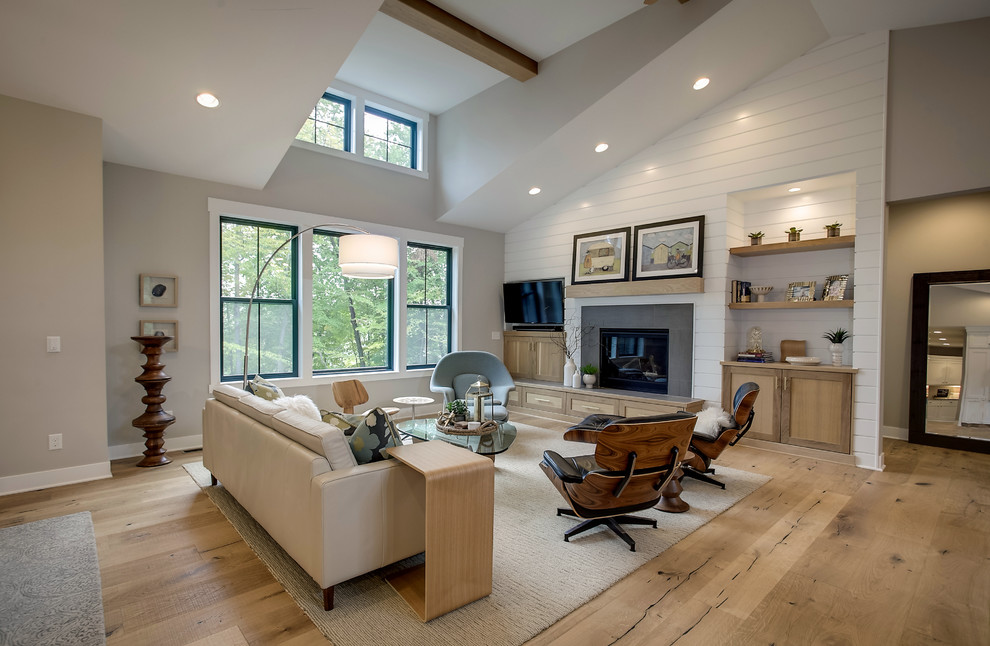 Country Wohnzimmer mit grauer Wandfarbe, braunem Holzboden, Kamin und braunem Boden in Grand Rapids