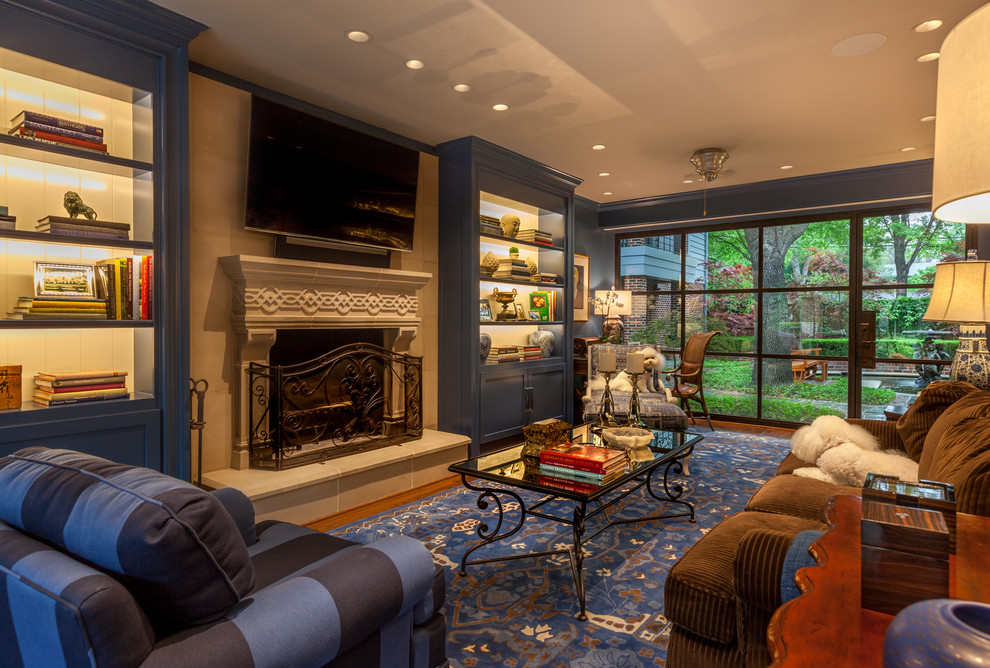 Example of a mid-sized classic enclosed medium tone wood floor living room design in Dallas with blue walls, a standard fireplace, a stone fireplace and a wall-mounted tv