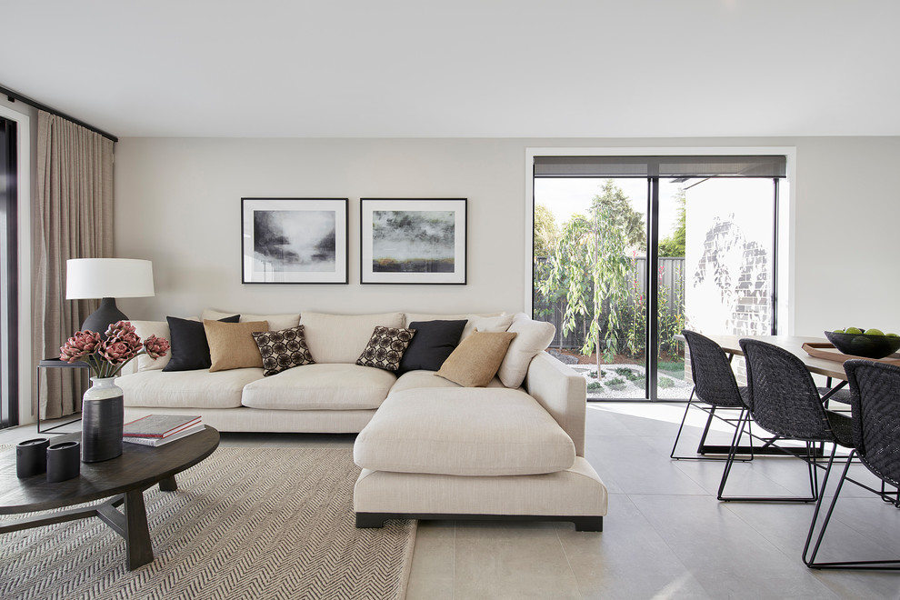 Cette photo montre un salon tendance de taille moyenne et ouvert avec un mur beige, un sol en carrelage de porcelaine, aucune cheminée et un sol gris.