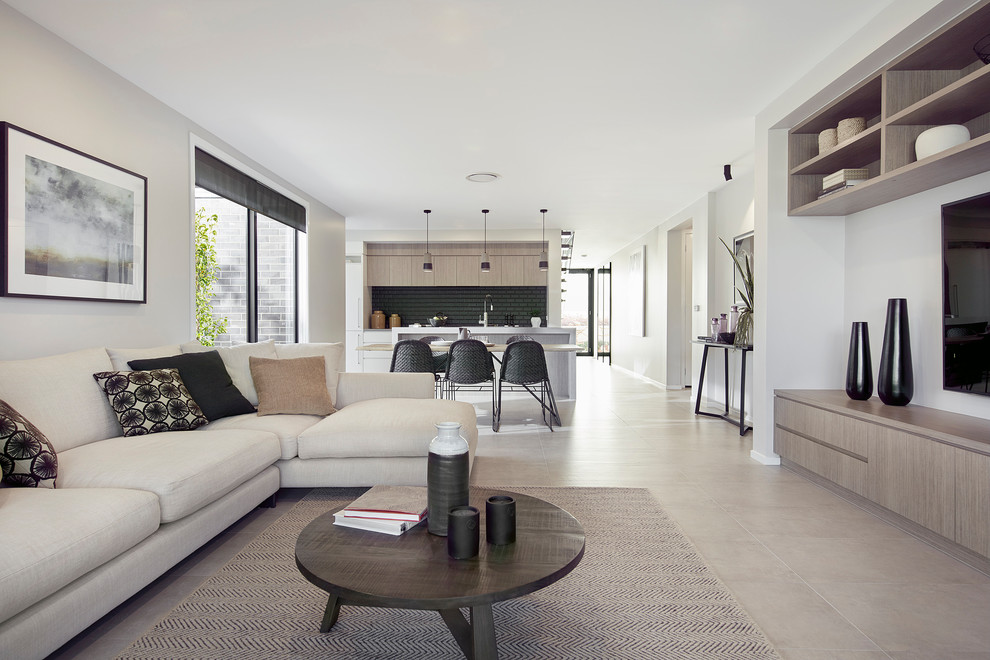 Immagine di un soggiorno design di medie dimensioni e aperto con pareti beige, pavimento in gres porcellanato, nessun camino e pavimento grigio
