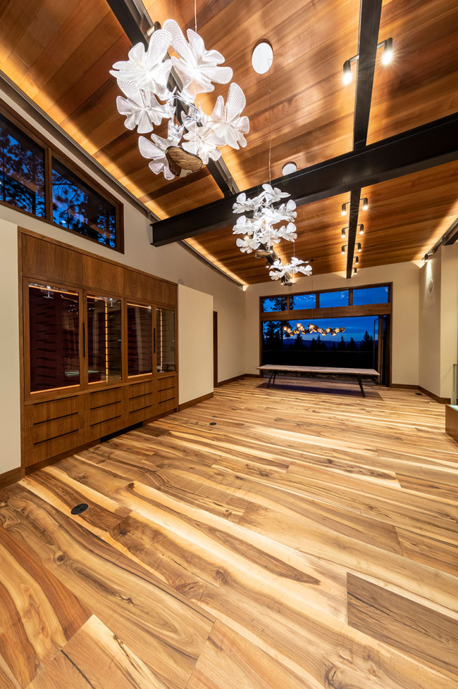 Immagine di un grande soggiorno minimal aperto con pareti bianche, pavimento in legno massello medio, pavimento marrone e travi a vista