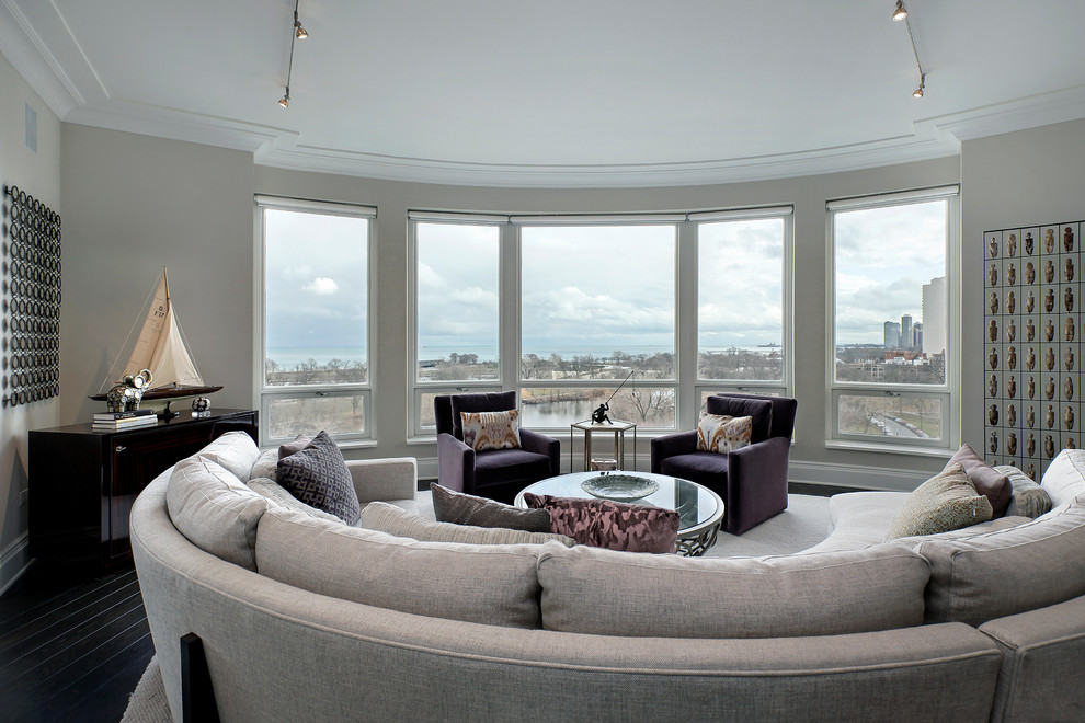 Пример оригинального дизайна: открытая гостиная комната в современном стиле с серыми стенами и темным паркетным полом без телевизора