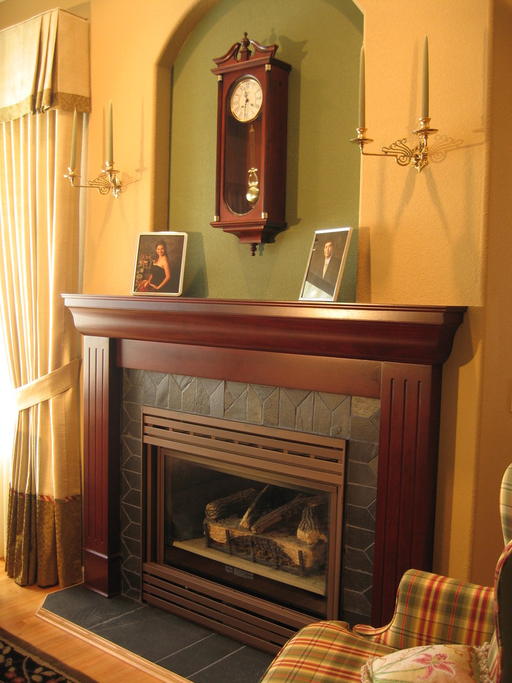 ボイシにあるトラディショナルスタイルのおしゃれなリビング (ベージュの壁、無垢フローリング、標準型暖炉、タイルの暖炉まわり、茶色い床) の写真