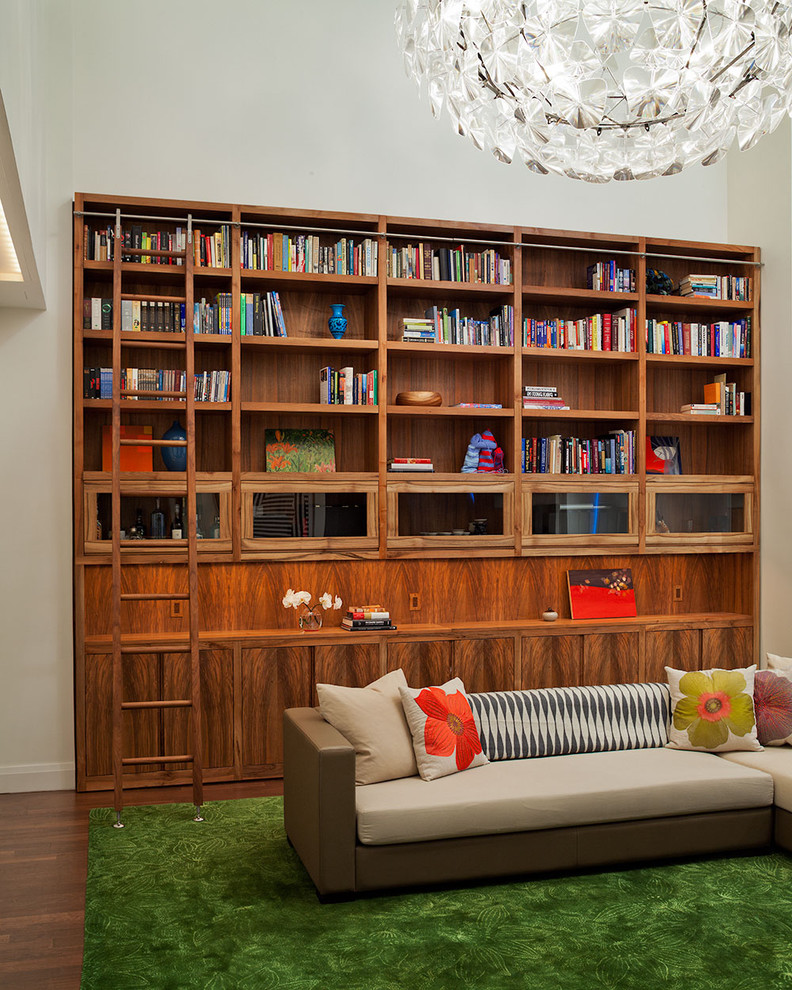 Aménagement d'un salon éclectique avec une bibliothèque ou un coin lecture et un mur beige.