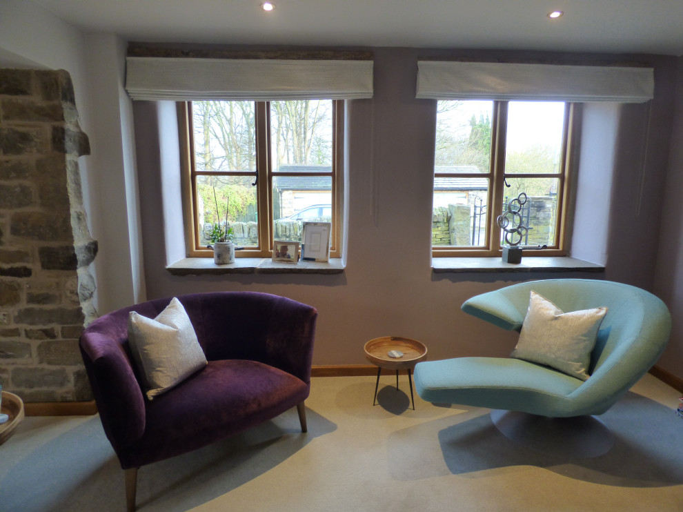 Cette photo montre un grand salon tendance ouvert avec une salle de réception, un mur violet, moquette, un poêle à bois, un manteau de cheminée en brique, un téléviseur d'angle, un sol gris et poutres apparentes.
