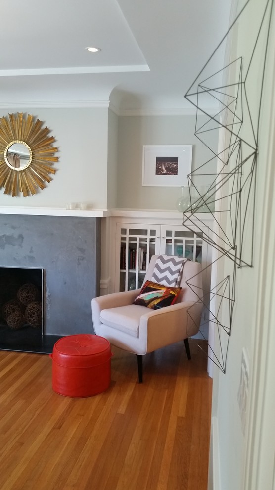 This is an example of a medium sized contemporary open plan living room in San Francisco with grey walls, medium hardwood flooring, a standard fireplace, a concrete fireplace surround and a freestanding tv.