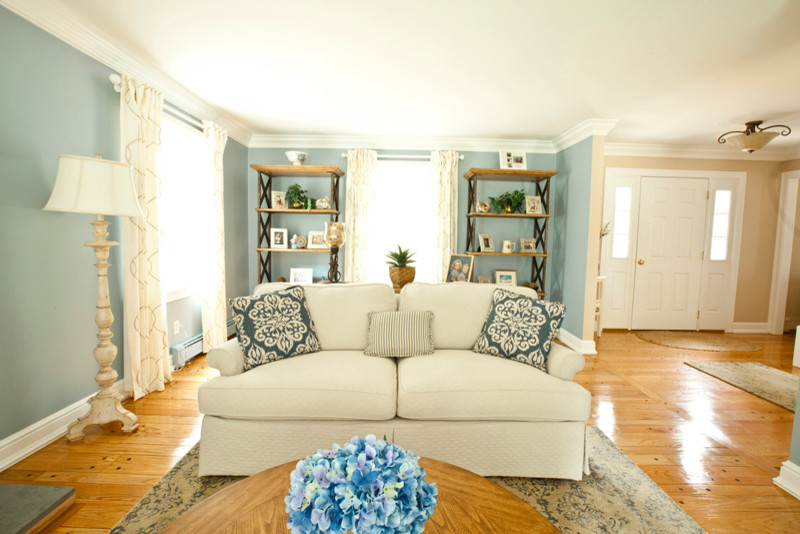 Immagine di un soggiorno chic di medie dimensioni e chiuso con sala formale, pareti blu, pavimento in legno massello medio, camino classico e cornice del camino in legno