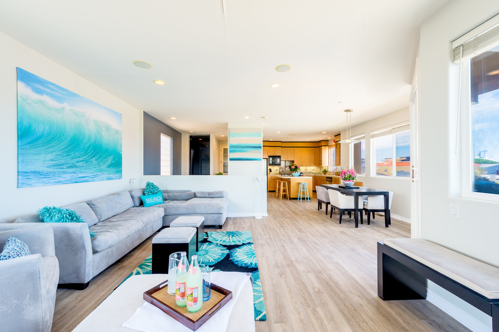 Coastal living room in Los Angeles with white walls and light hardwood flooring.