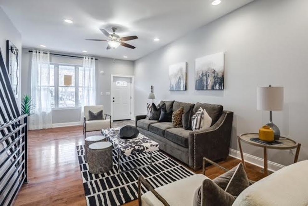 This is an example of a large contemporary open plan living room in Philadelphia with grey walls, medium hardwood flooring, no fireplace, no tv and brown floors.