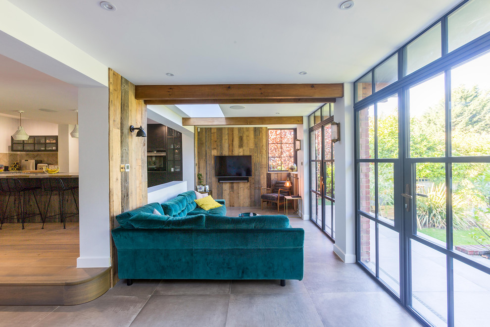 Aménagement d'un salon contemporain de taille moyenne et fermé avec un mur gris, un sol en bois brun, une cheminée standard, un manteau de cheminée en métal et un sol marron.