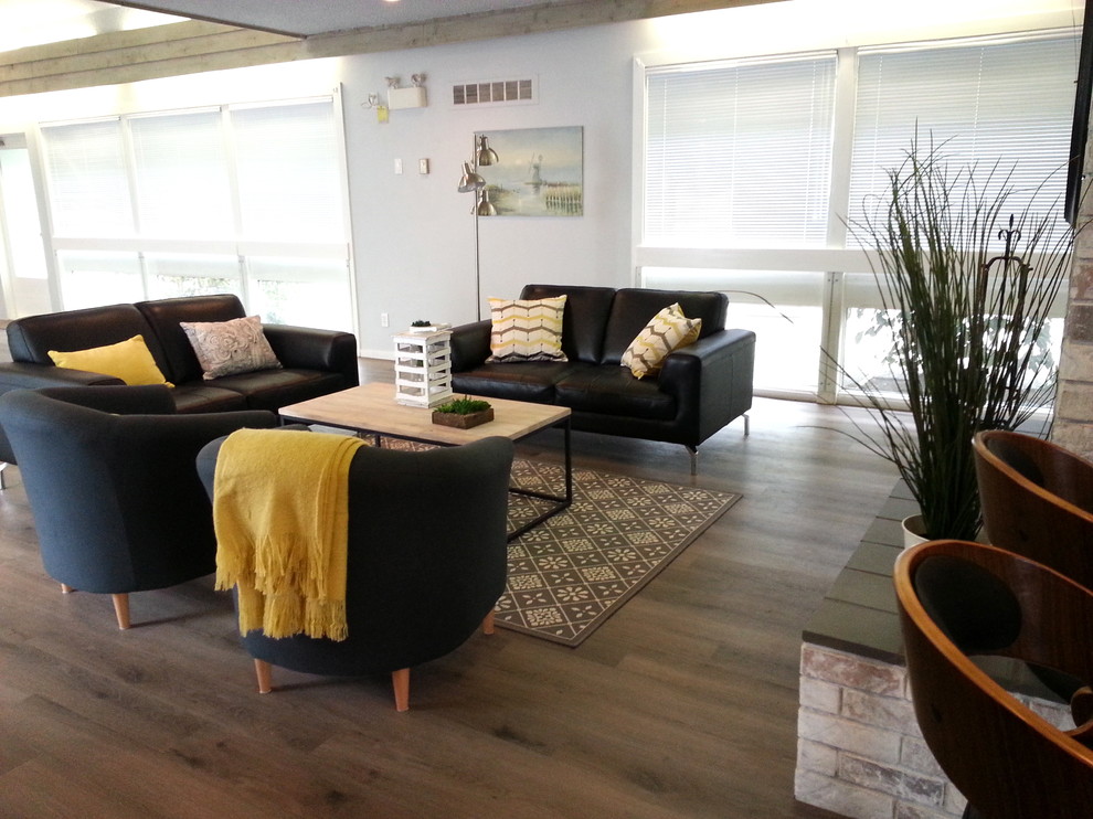 Großes Modernes Wohnzimmer mit grauer Wandfarbe, Vinylboden und Kaminumrandung aus Backstein in Vancouver