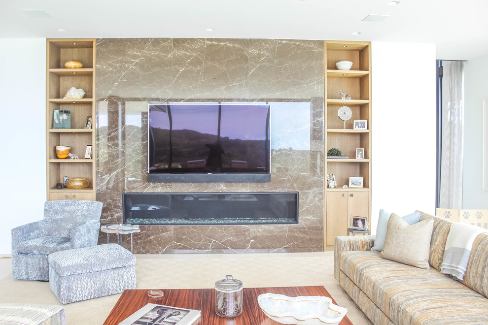 Modelo de salón abierto contemporáneo grande con paredes beige, chimenea lineal, marco de chimenea de piedra y televisor colgado en la pared
