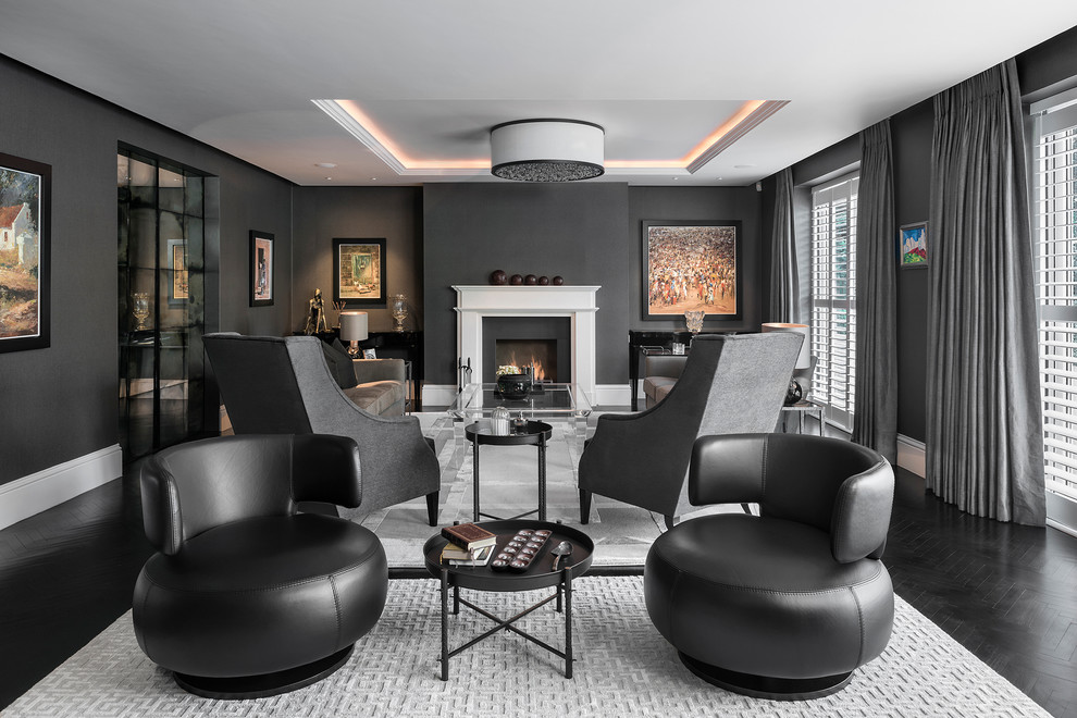 Пример оригинального дизайна: большая парадная, изолированная гостиная комната:: освещение в современном стиле с черными стенами, темным паркетным полом, стандартным камином, фасадом камина из камня, черным полом и ковром на полу без телевизора