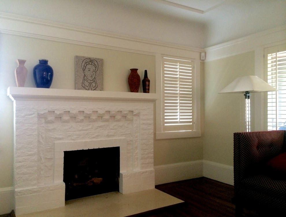 This is an example of a medium sized mediterranean living room in New York with white walls, dark hardwood flooring, a standard fireplace and a brick fireplace surround.