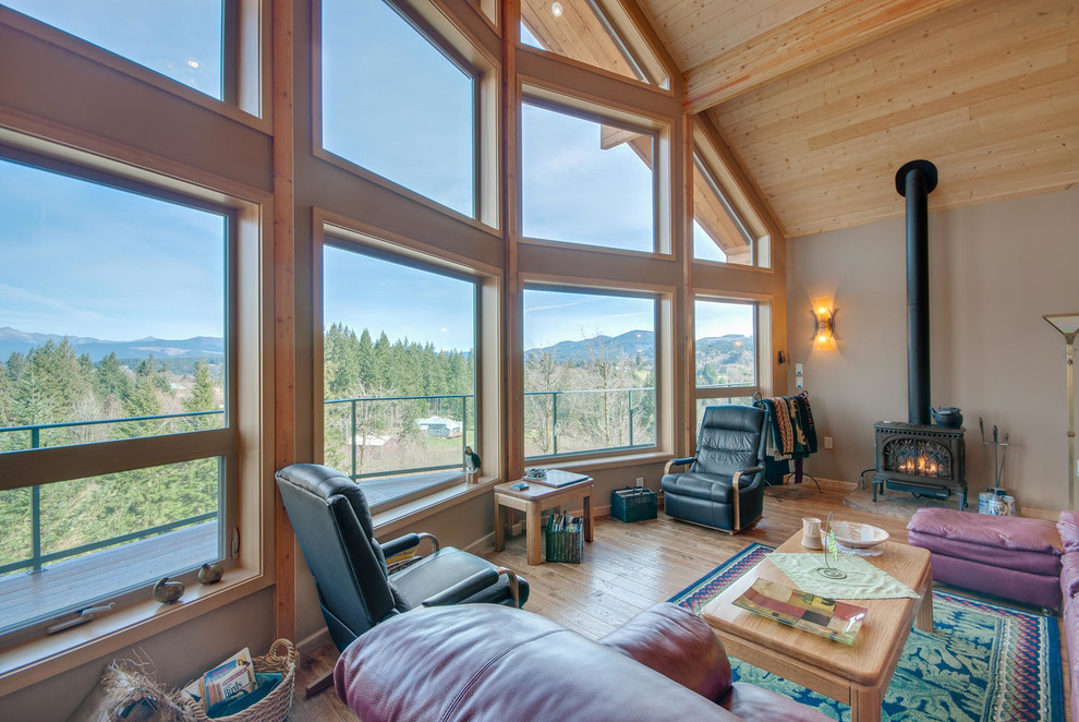 Foto di un grande soggiorno american style aperto con pareti beige, pavimento in legno massello medio e stufa a legna