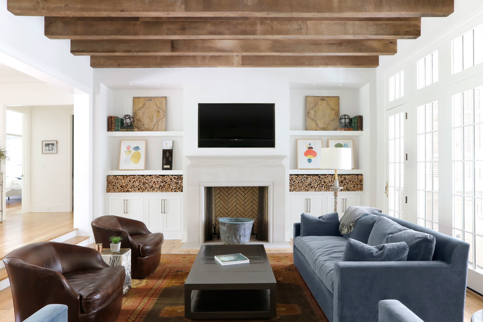 Источник вдохновения для домашнего уюта: изолированная гостиная комната в стиле фьюжн с белыми стенами, светлым паркетным полом, стандартным камином и телевизором на стене