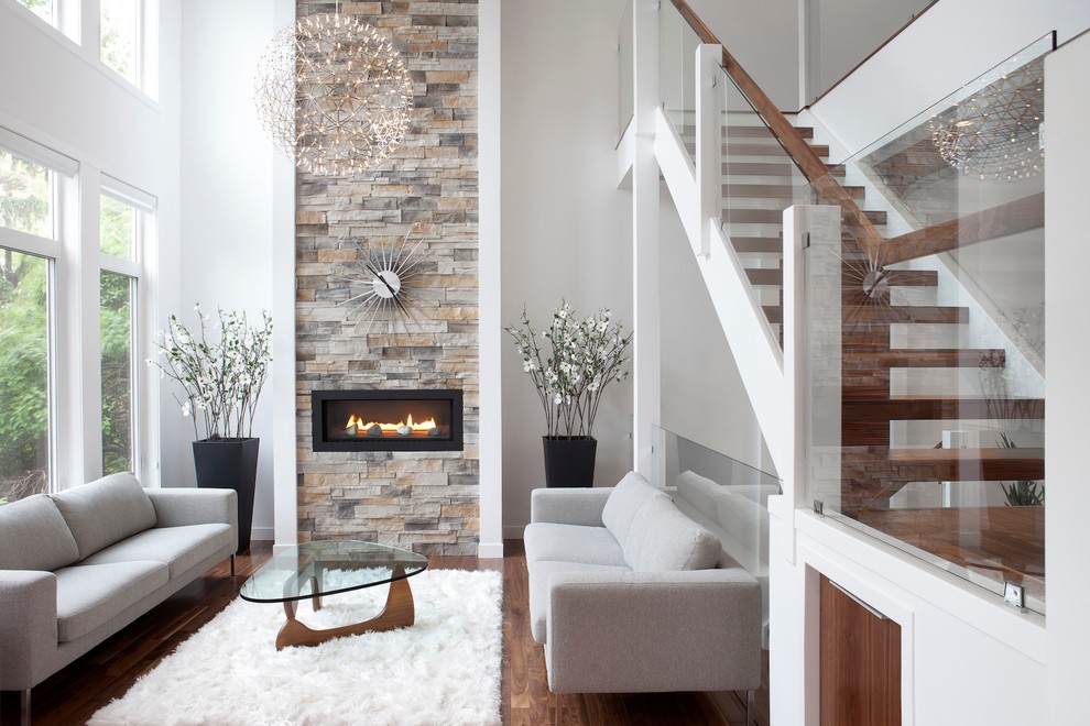 Photo of a contemporary grey and teal living room in Calgary with a ribbon fireplace and a stone fireplace surround.