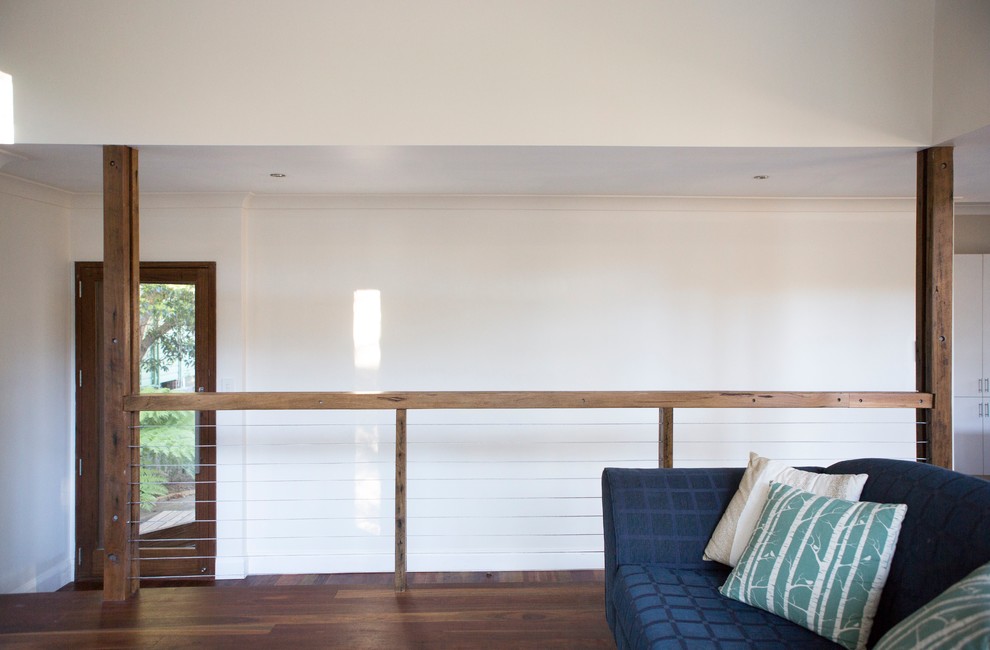 This is an example of a medium sized contemporary open plan living room in Wollongong with white walls, dark hardwood flooring and a wall mounted tv.
