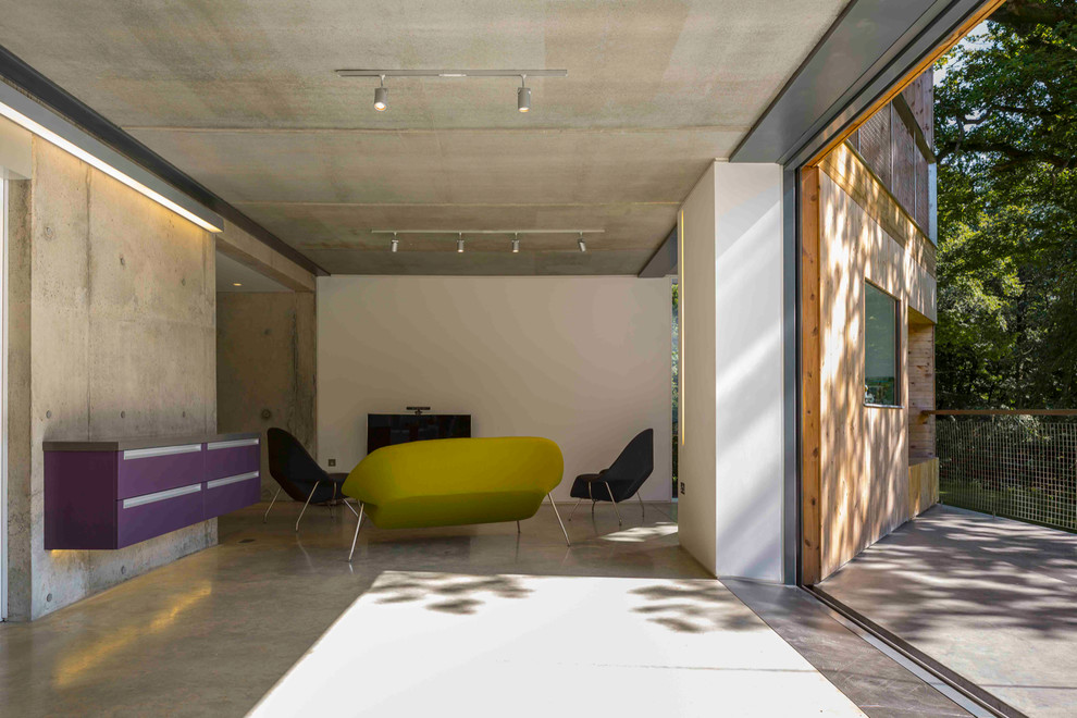 Idéer för ett stort modernt separat vardagsrum, med vita väggar, betonggolv, en standard öppen spis, en spiselkrans i trä och en fristående TV