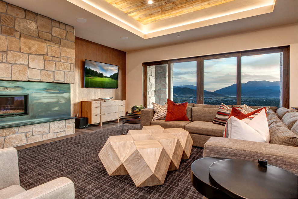 Offenes Klassisches Wohnzimmer mit weißer Wandfarbe, braunem Holzboden, Gaskamin, Kaminumrandung aus Stein, TV-Wand und braunem Boden in Salt Lake City