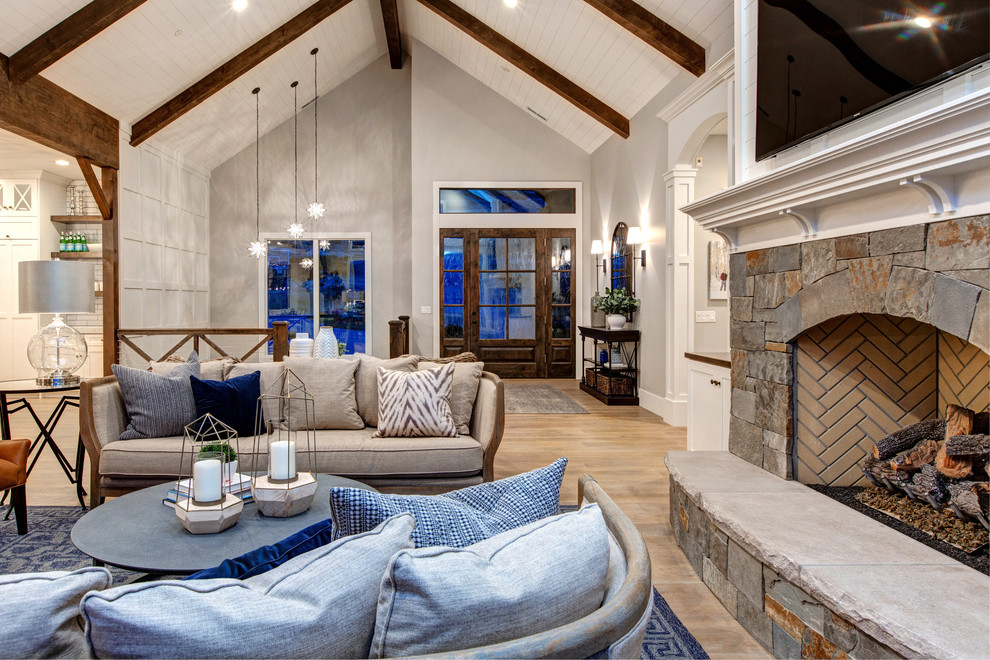 Large cottage open concept medium tone wood floor living room photo in Salt Lake City with white walls, a standard fireplace, a stone fireplace and a wall-mounted tv