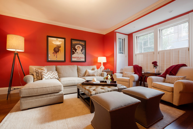 Idée de décoration pour un grand salon bohème fermé avec un mur rouge et un sol en bois brun.