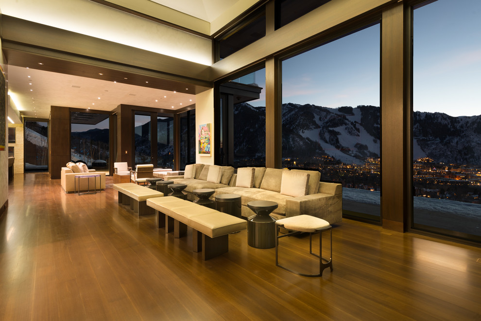 This is an example of a contemporary open plan living room in Denver with beige walls and medium hardwood flooring.