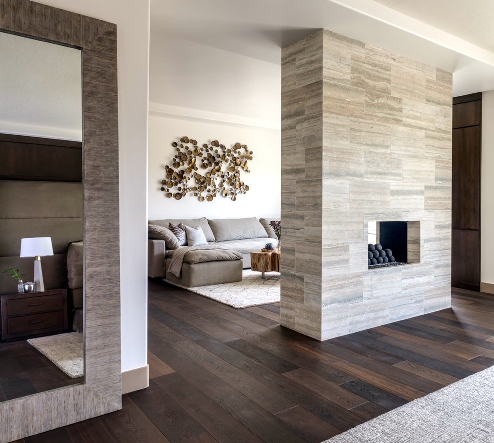 This is an example of an expansive modern enclosed living room in Las Vegas with white walls, porcelain flooring, a two-sided fireplace, a tiled fireplace surround and a wall mounted tv.