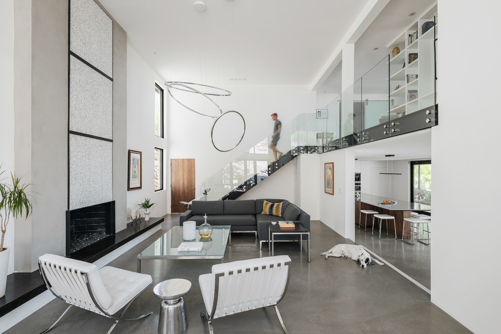 Свежая идея для дизайна: большая гостиная комната в современном стиле с белыми стенами, бетонным полом, стандартным камином и фасадом камина из бетона без телевизора - отличное фото интерьера