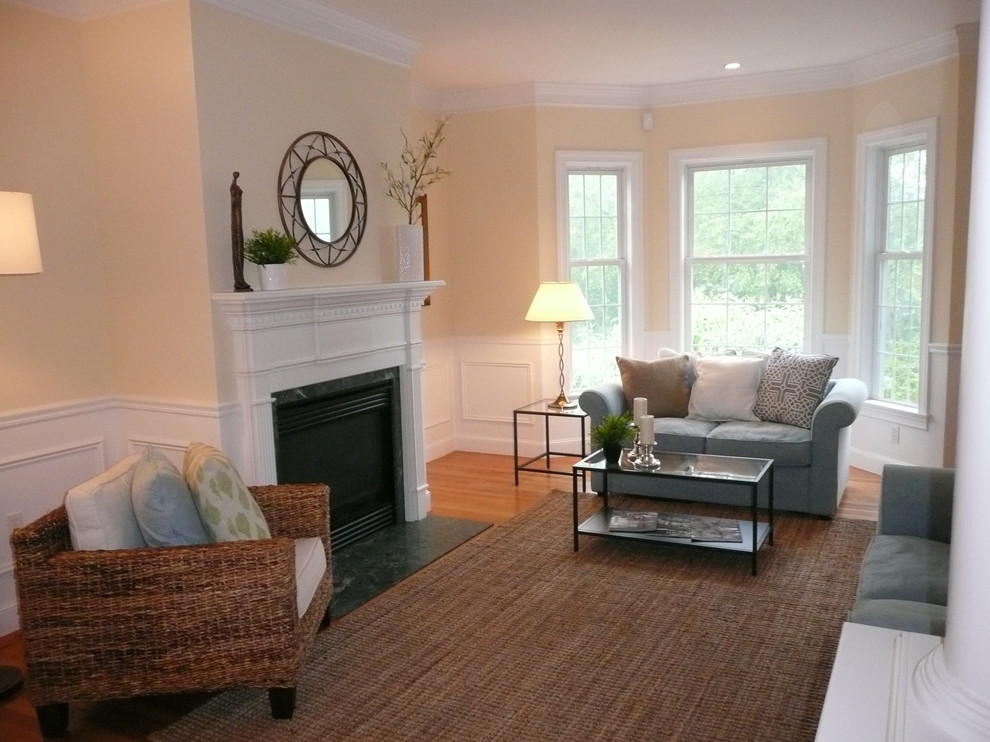Example of a small transitional enclosed medium tone wood floor living room design in Boston with yellow walls, a standard fireplace and a wood fireplace surround
