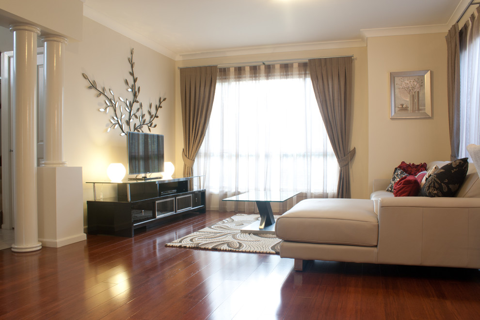 На фото: изолированная гостиная комната среднего размера в современном стиле с бежевыми стенами, паркетным полом среднего тона и отдельно стоящим телевизором