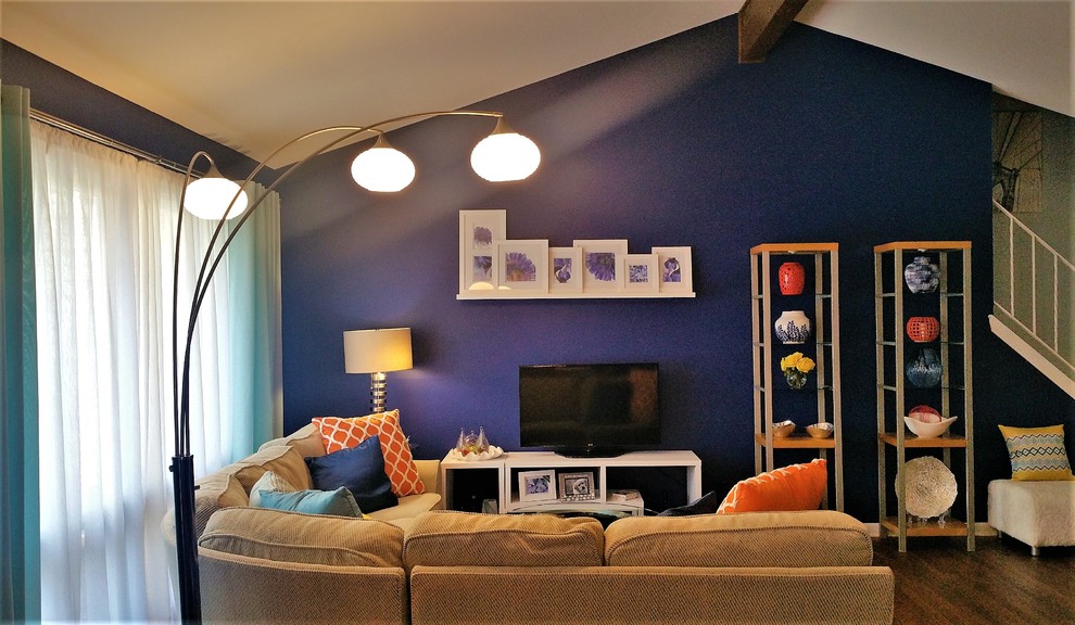 Cette photo montre un salon éclectique de taille moyenne et ouvert avec un mur bleu, un sol en bois brun, aucune cheminée, un téléviseur indépendant et un sol marron.