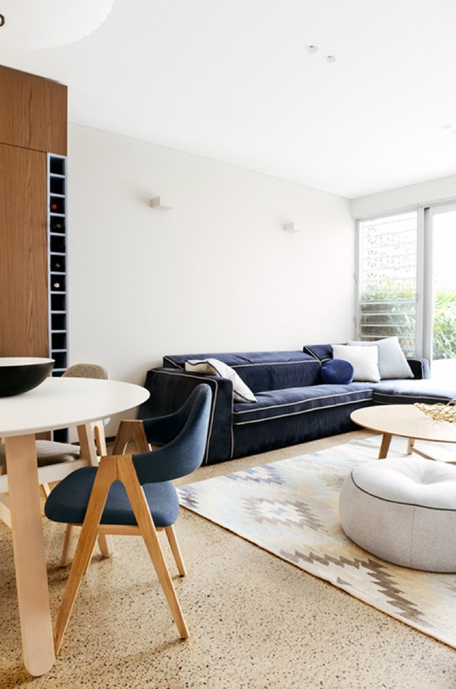 Diseño de salón abierto moderno pequeño con paredes blancas, suelo de cemento y televisor independiente