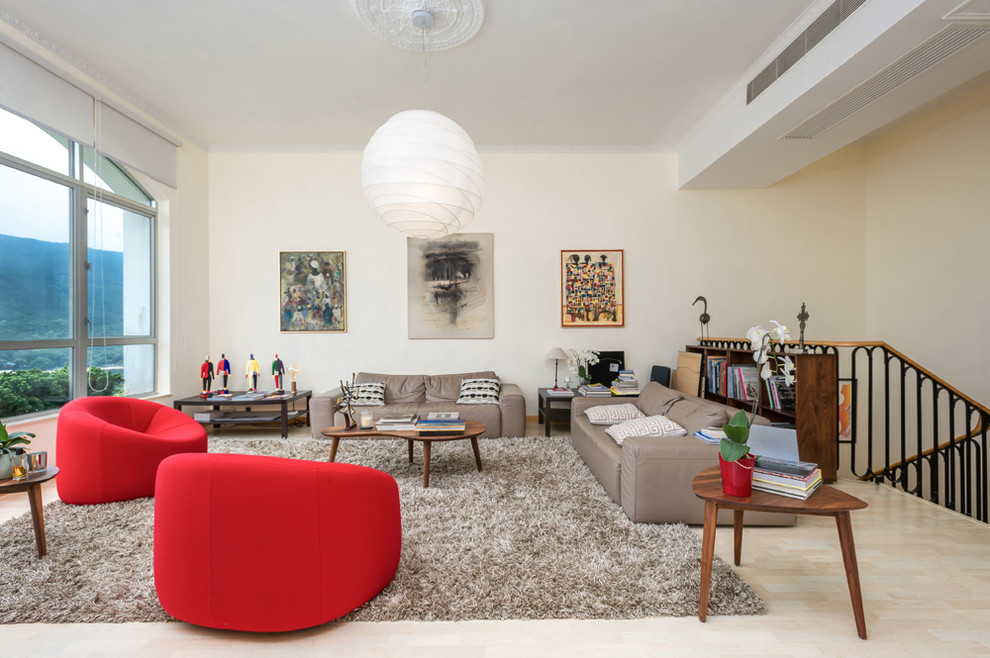 This is an example of a contemporary living room in Hong Kong with beige walls, no fireplace and beige floors.