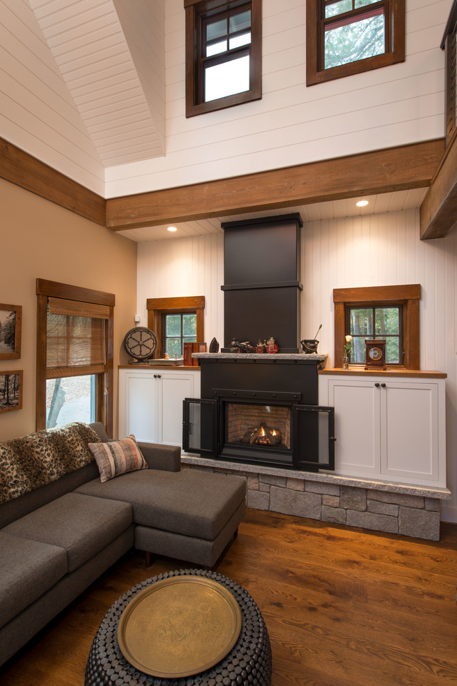 Example of a small farmhouse formal and open concept medium tone wood floor living room design in Boston with white walls, a wood stove, a metal fireplace and a wall-mounted tv