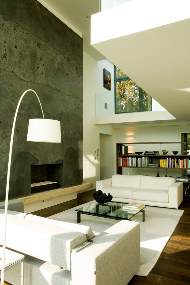 Offenes Modernes Wohnzimmer mit braunem Holzboden, Kamin, Kaminumrandung aus Beton und freistehendem TV in London
