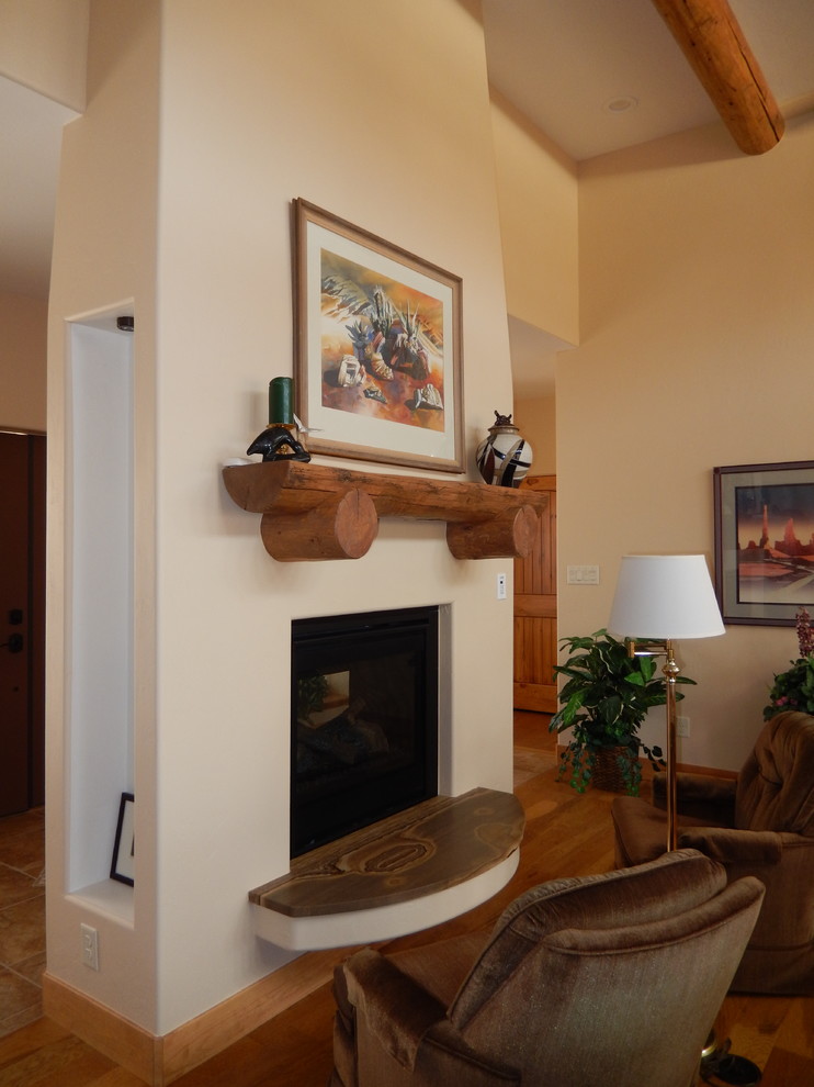 Foto på ett mellanstort amerikanskt allrum med öppen planlösning, med beige väggar, mellanmörkt trägolv, en dubbelsidig öppen spis, en spiselkrans i gips, en väggmonterad TV och brunt golv