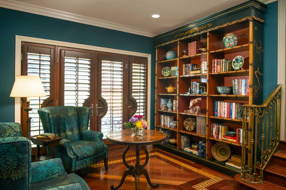 Inredning av ett eklektiskt mellanstort separat vardagsrum, med mörkt trägolv, brunt golv, ett bibliotek och blå väggar