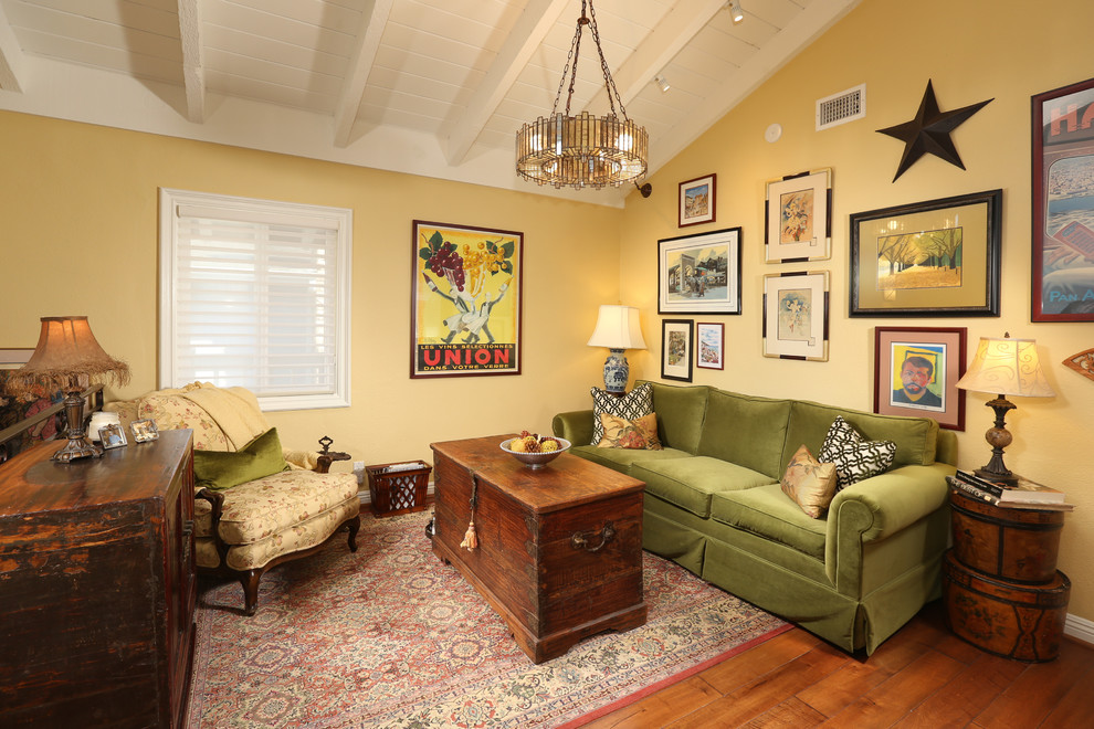 Diseño de salón para visitas tipo loft ecléctico de tamaño medio sin televisor y chimenea con paredes amarillas, suelo de madera en tonos medios y suelo marrón