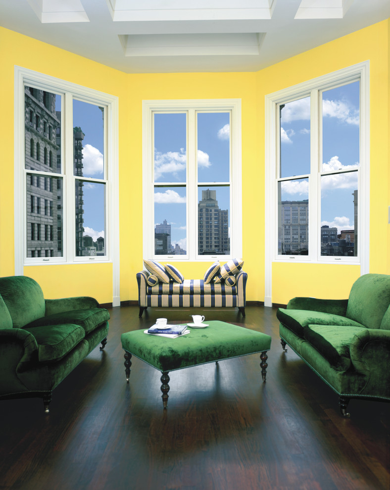 На фото: большая парадная, изолированная гостиная комната в стиле ретро с желтыми стенами и темным паркетным полом без камина, телевизора