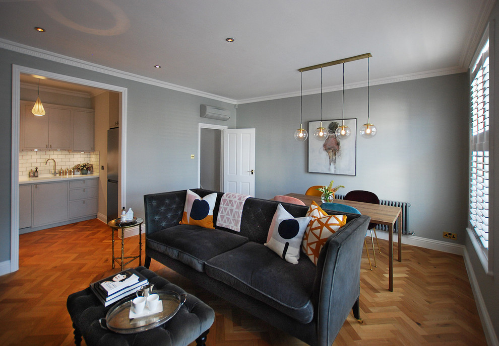 Kleines, Offenes Modernes Wohnzimmer mit braunem Holzboden, Kamin, verputzter Kaminumrandung, freistehendem TV, braunem Boden und grauer Wandfarbe in London