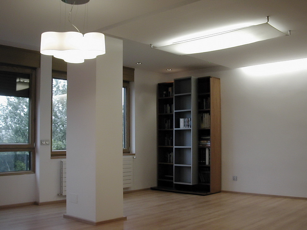 Diseño de salón cerrado actual de tamaño medio con paredes blancas y suelo de madera clara