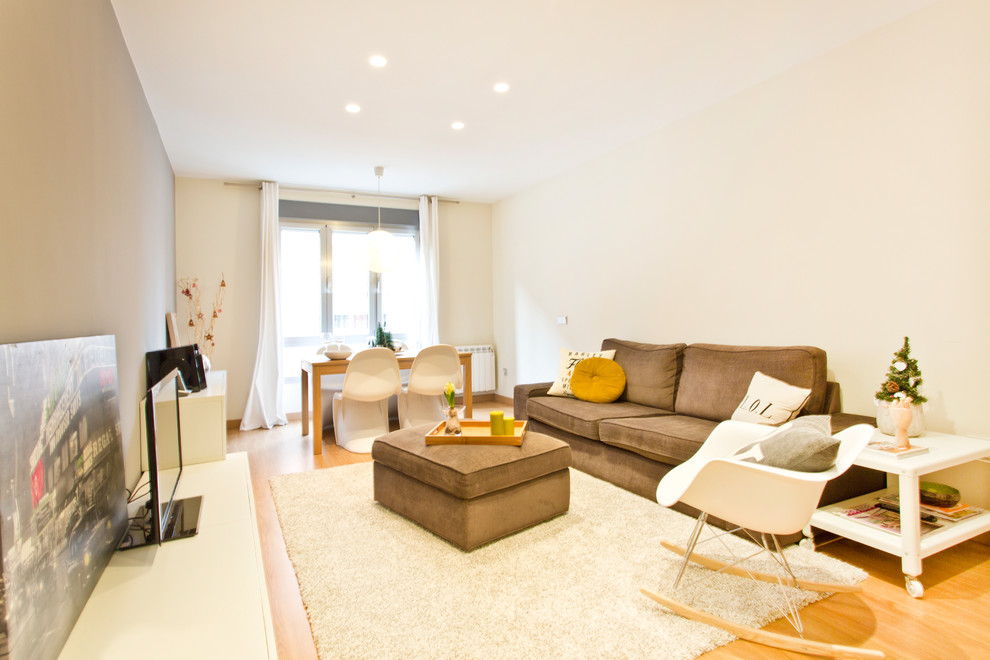 Imagen de salón para visitas abierto nórdico grande sin chimenea con paredes beige, suelo de madera clara, televisor independiente y cortinas