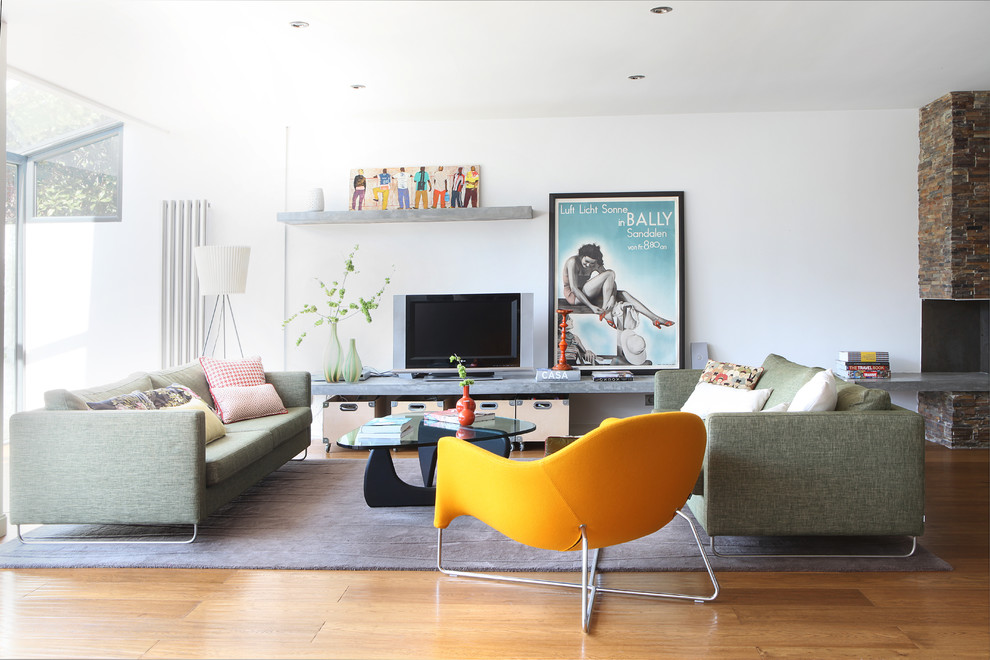 Diseño de salón para visitas abierto contemporáneo grande con paredes blancas, suelo de madera en tonos medios y televisor independiente